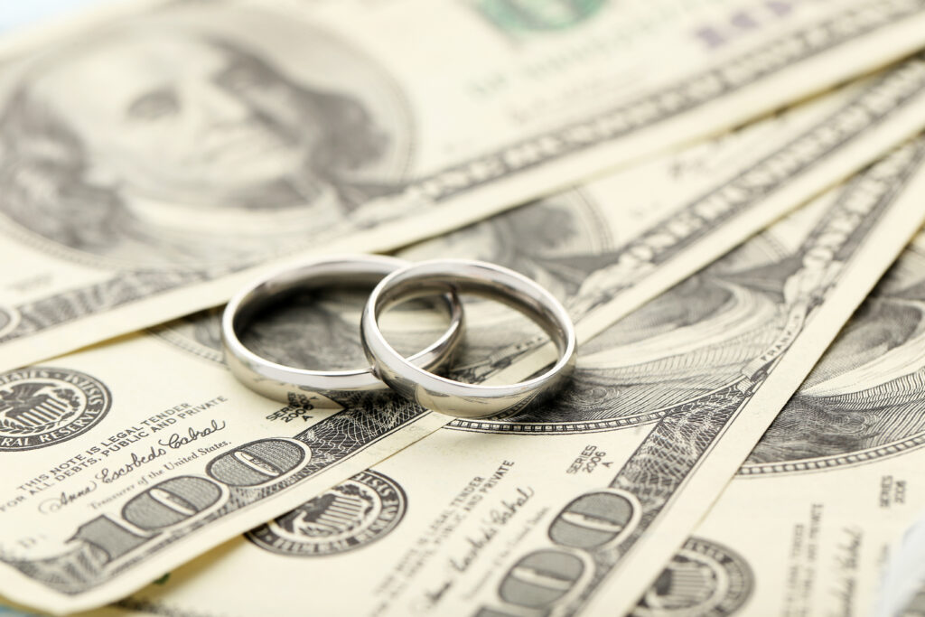 silver wedding rings on one hundred dollars bill background